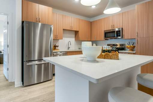 A modern kitchen with a white countertop and wooden cabinets.
