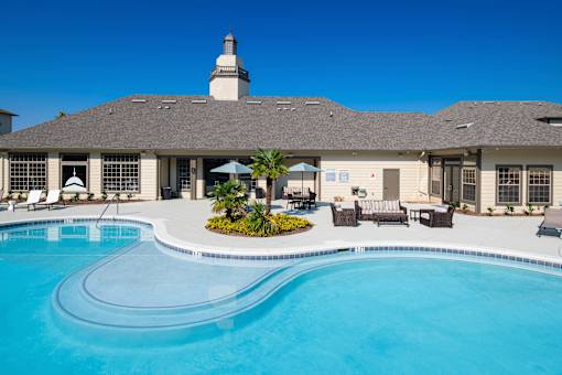 A large building with a pool in front of it.