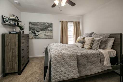 A bedroom with a large bed and a dresser.