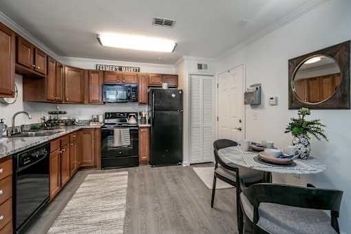 A kitchen with a refrigerator, stove, and microwave.