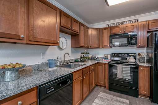 A kitchen with wooden cabinets and a black stove top oven.