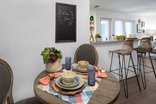 A dining table with a chalkboard on the wall.