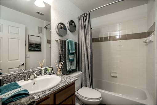 A bathroom with a white toilet, a white sink, and a white bathtub.
