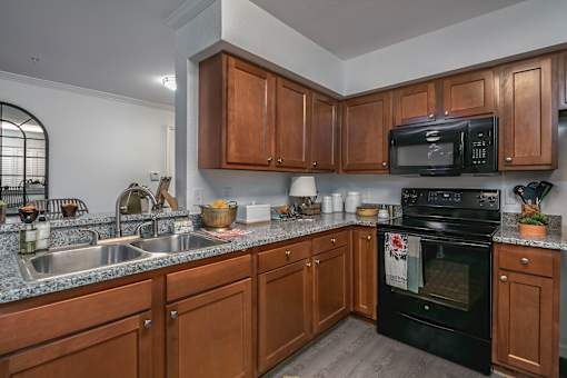 A kitchen with wooden cabinets and a black oven.