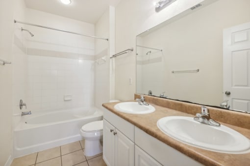 a bathroom with two sinks and a tub and a toilet
