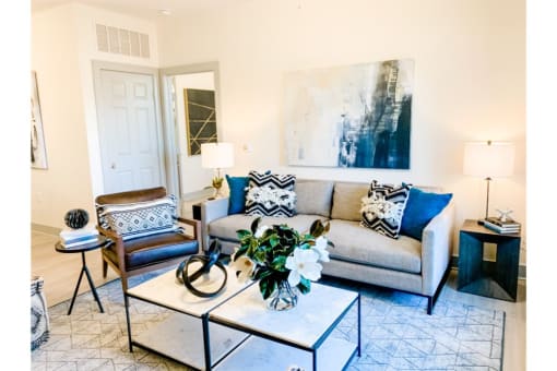 a living room with a gray couch and blue and white pillows