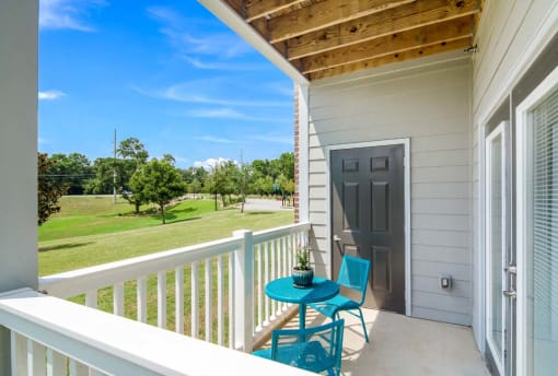 a patio with two chairs and a table on a balcony