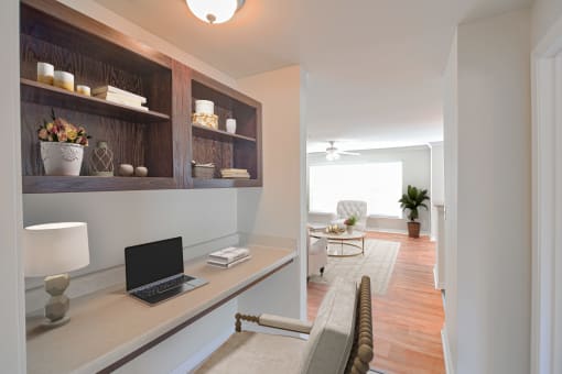 A laptop is open on a desk with a lamp and a plant in the room at 10X Audubon Park apartments in Daphne, AL 