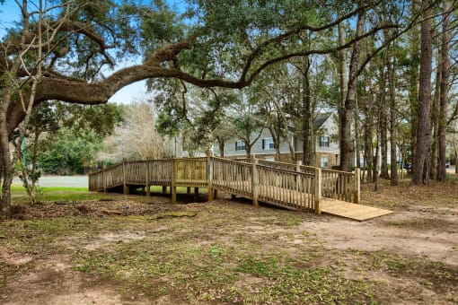 A wooden deck is surrounded by trees in a wooded area at 10X Audubon Park apartments in Daphne, AL 