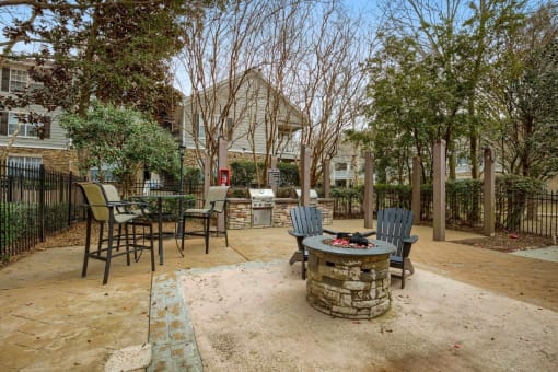 a patio with chairs and a fire pit at 10X Audubon Park apartments in Daphne, AL 