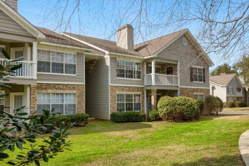A row of houses with a green lawn in front at 10X Audubon Park apartments in Daphne, AL 
