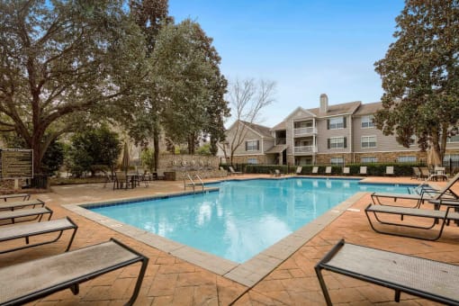 our apartments offer a swimming pool with our apartment buildings in the background at 10X Audubon Park apartments in Daphne, AL 