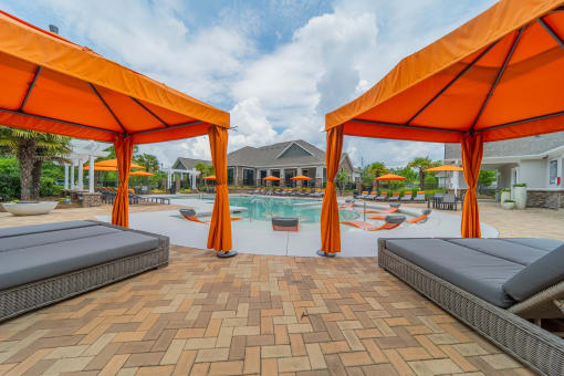 our apartments have a pool and cabanas with orange umbrellas