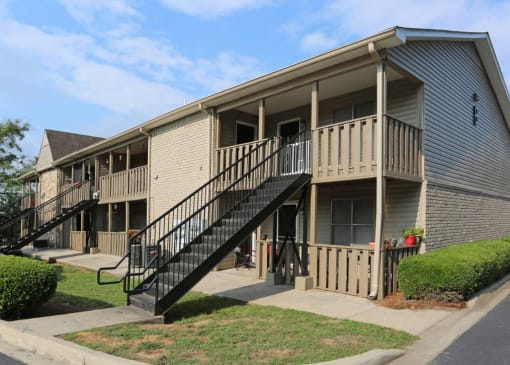 the exterior of an apartment building with stairs and balconies