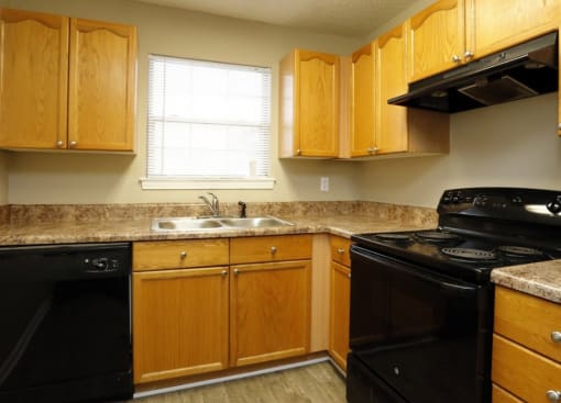 a kitchen with black appliances and wooden cabinets