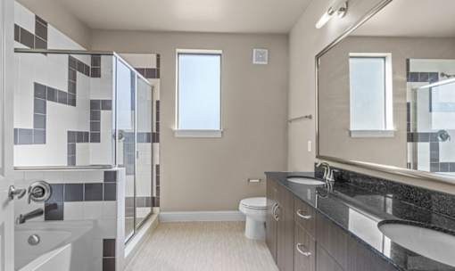 Modern bathroom with dual vanity and glass shower at Matilda at Lower Greenville Apartments, Dallas, TX