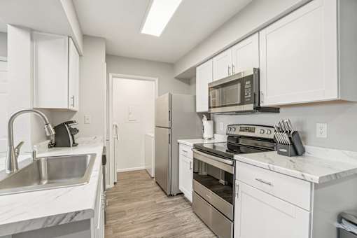 A kitchen with white cabinets and stainless steel appliances.