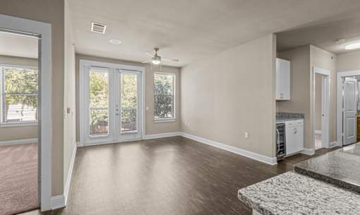 Open living area with patio access and hardwood floors at Matilda at Lower Greenville Apartments, Texas