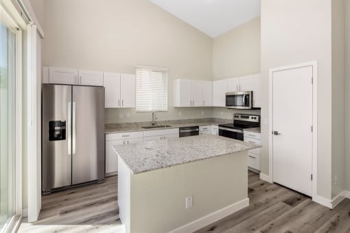 a kitchen with white cabinets and a granite counter top
