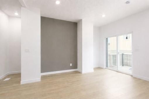 A large empty room with wooden floors and white walls.