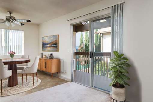 a living room with a patio door and a table and chairs