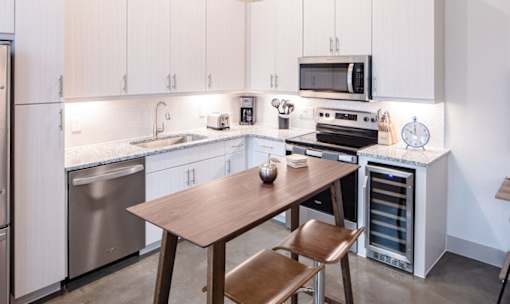 Modern kitchen with granite countertops and island at Avion at West Lemmon Apartments, Dallas, 75235