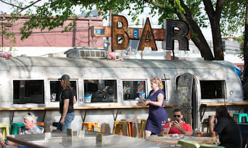 Outdoor bar with vintage airstream and patio seating at Matilda at Lower Greenville Apartments, Dallas, TX 75206