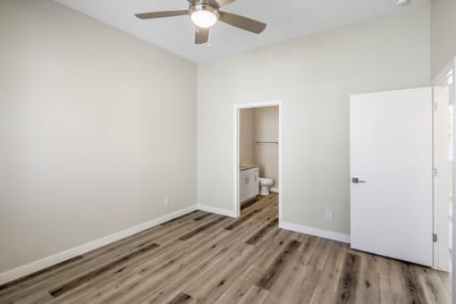 a bedroom with hardwood floors and a ceiling fan