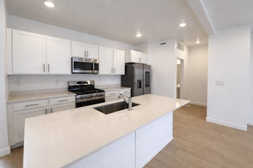 A kitchen with white cabinets and a countertop.