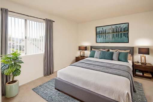 a bedroom with a bed and a large window