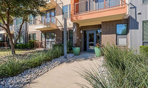 Apartment community entrance with landscaped walkway at Matilda at Lower Greenville Apartments, Dallas, TX 75206