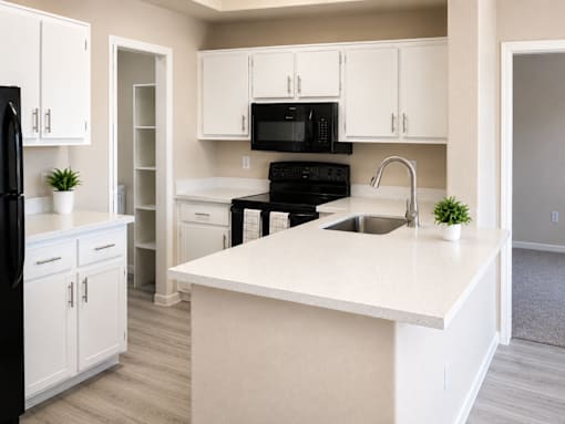 Modern kitchen with white cabinetry and island at Cortina Apartments, Phoenix