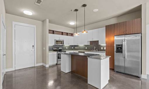Contemporary kitchen with granite countertops and pendant lights at Matilda at Lower Greenville Apartments, Dallas, TX
