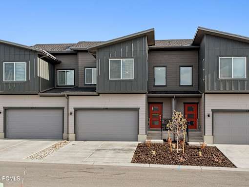 A modern house with grey walls and red doors.