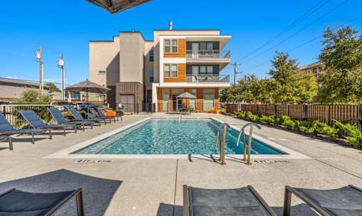 Resort style pool with lounge seating at Avion at West Lemmon Apartments, Texas
