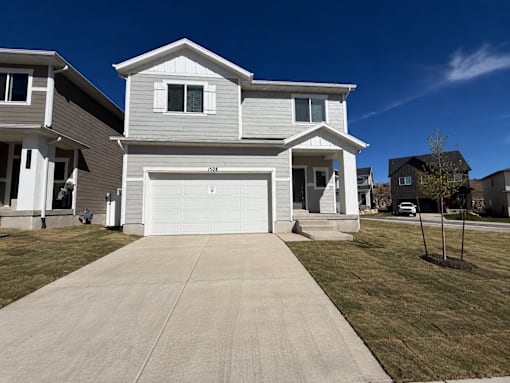 A two-story house with a garage is situated in a residential area.