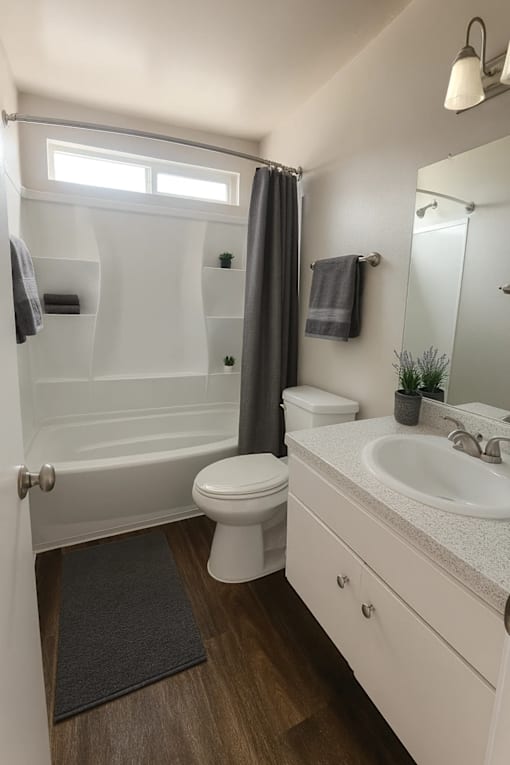 A white bathroom with a toilet, sink, and bathtub.