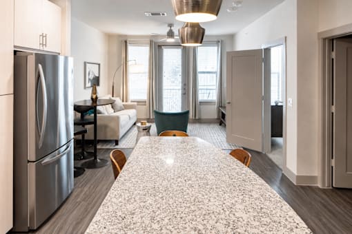 Open kitchen with granite island and living area at Avion at West Lemmon Apartments, Dallas, TX 75235