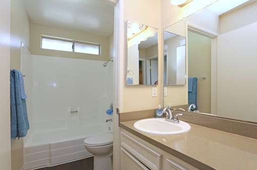 A bathroom with a white toilet, sink, and a blue towel.