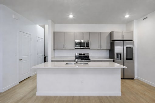 A modern kitchen with white cabinets and stainless steel appliances.