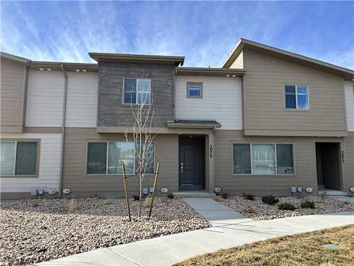 A modern two-story house with a grey and beige exterior.