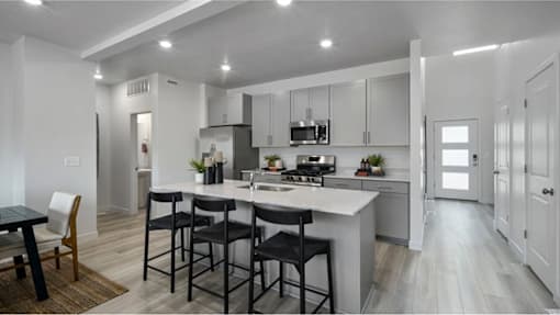 A modern kitchen with a dining table and chairs.