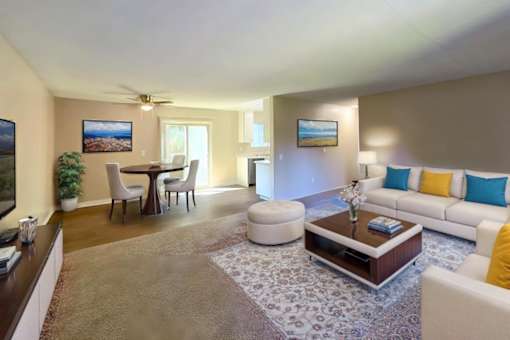 A living room with a white couch, a coffee table, and a ceiling fan.