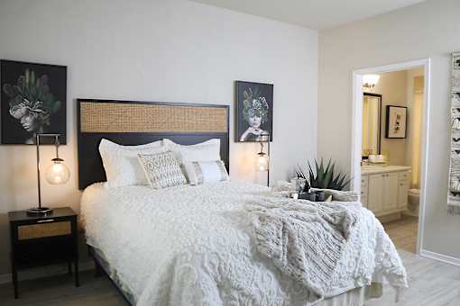 A bedroom with a large bed and two lamps on side tables.