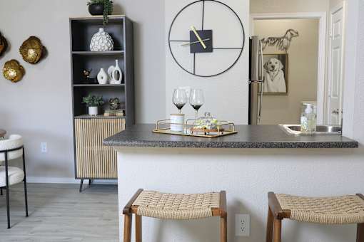 A kitchen with a bar area and two chairs.