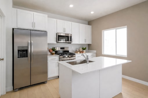 A modern kitchen with a stainless steel refrigerator and white cabinets.