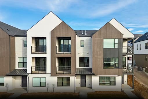 A modern residential building with a mix of white and brown exterior.