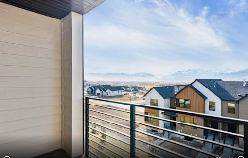 A balcony view of a snowy mountain range.