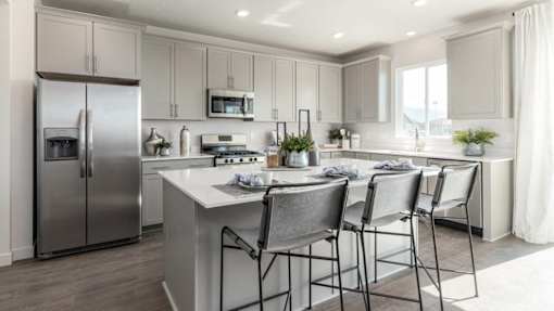 A modern kitchen with a refrigerator, stove, and sink.