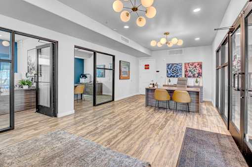 A modern office space with a wooden floor and a glass wall.